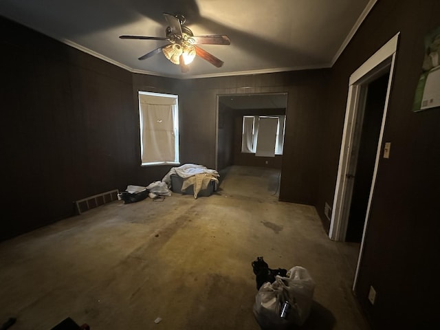 interior space with ceiling fan and crown molding