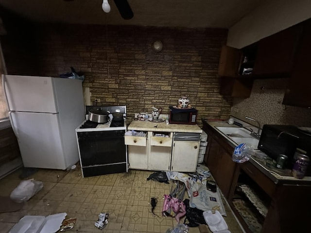 kitchen featuring white refrigerator, range with electric stovetop, and sink