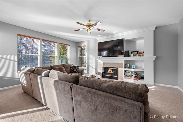 living room with ceiling fan, carpet, and a fireplace