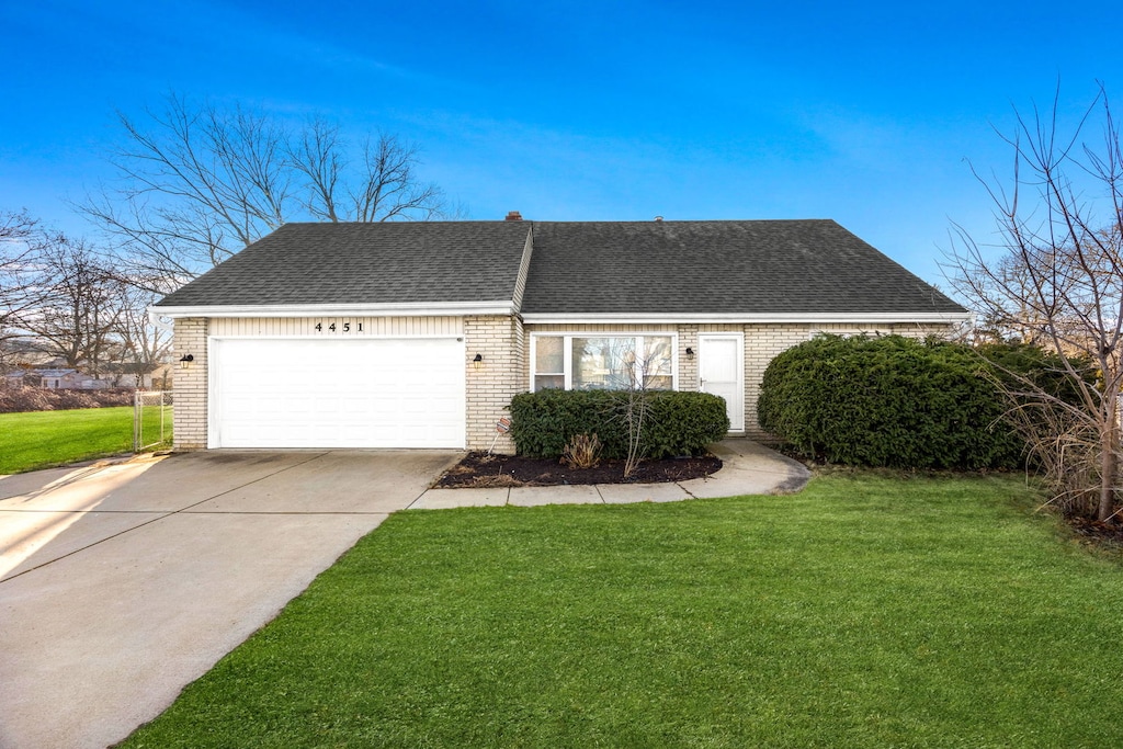 view of front of property with a garage and a front lawn