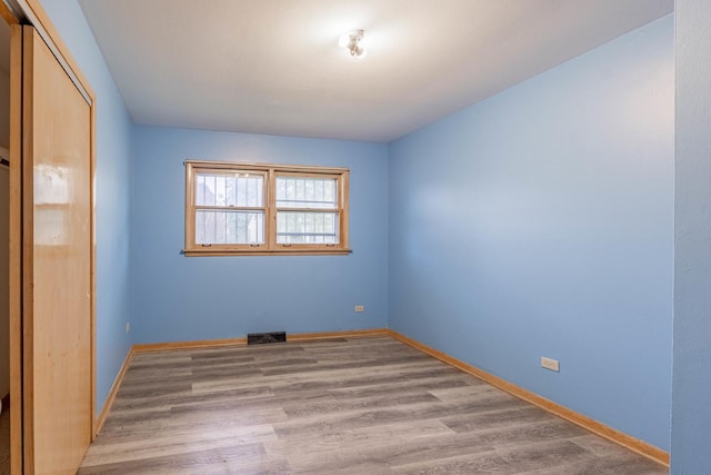 unfurnished bedroom with light hardwood / wood-style flooring and a closet