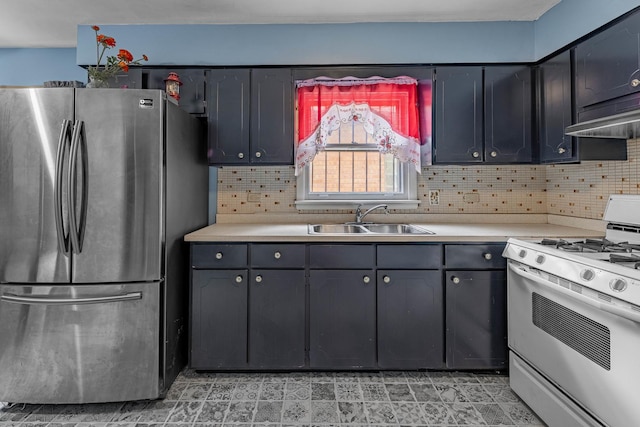 kitchen with decorative backsplash, range, sink, and stainless steel refrigerator