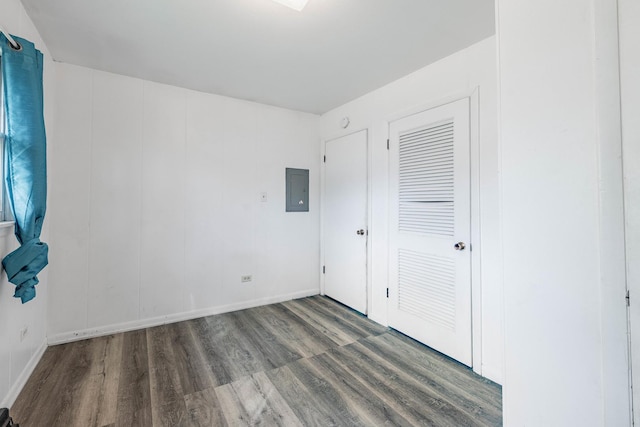 unfurnished bedroom with dark wood-type flooring and electric panel