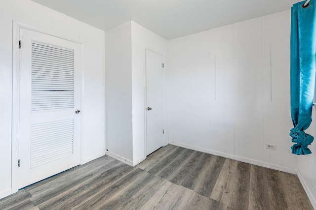 unfurnished room with dark wood-type flooring