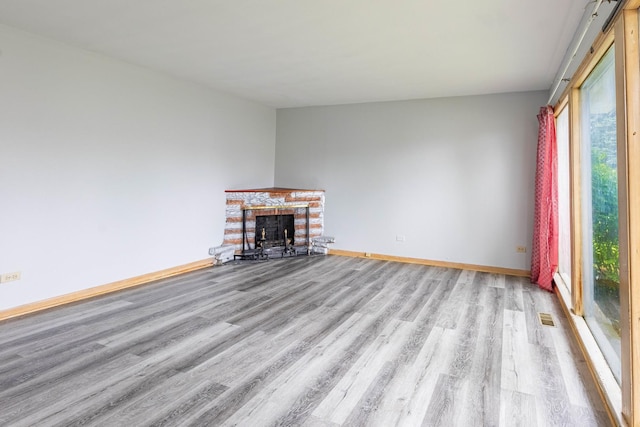 unfurnished living room with a fireplace and light wood-type flooring