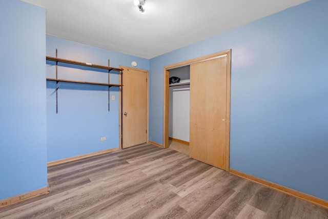 unfurnished bedroom with hardwood / wood-style flooring and a closet