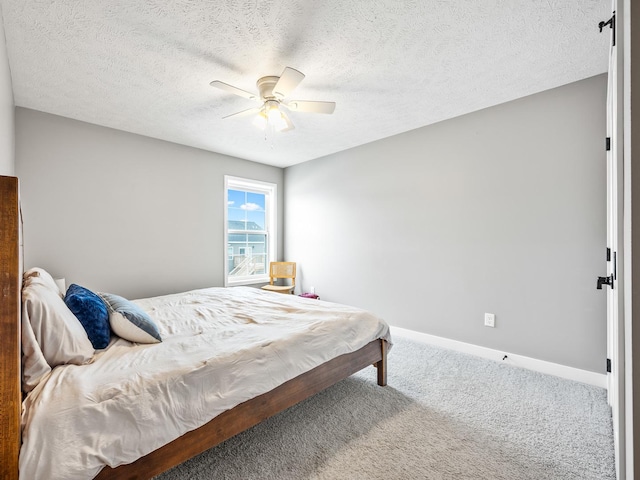 carpeted bedroom with ceiling fan and a textured ceiling