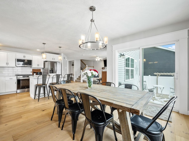 dining area with light hardwood / wood-style flooring and an inviting chandelier