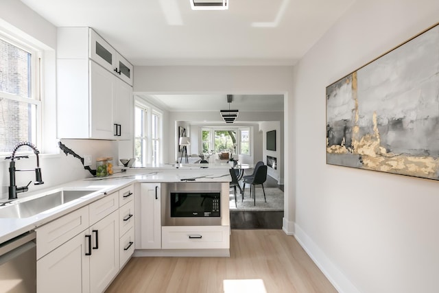 kitchen with white cabinets, built in microwave, dishwasher, and sink