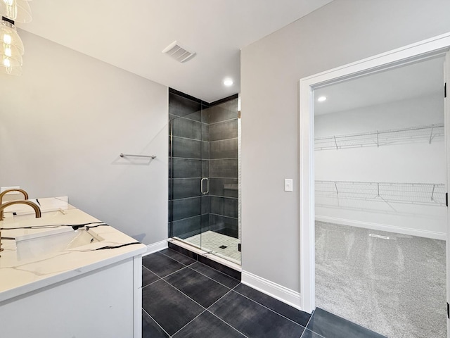 bathroom with tile patterned floors, vanity, and a shower with shower door