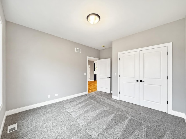 unfurnished bedroom with carpet flooring and a closet