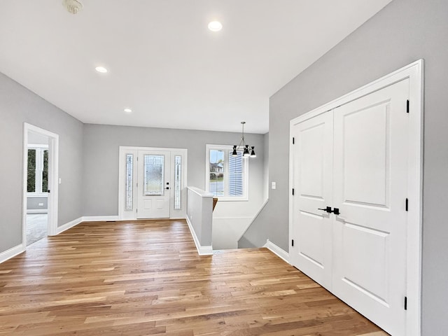 entryway featuring light hardwood / wood-style floors and an inviting chandelier