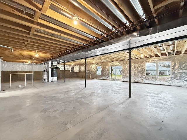 basement featuring a healthy amount of sunlight and water heater