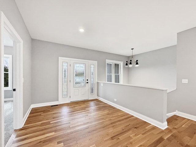 entrance foyer featuring hardwood / wood-style floors and a notable chandelier