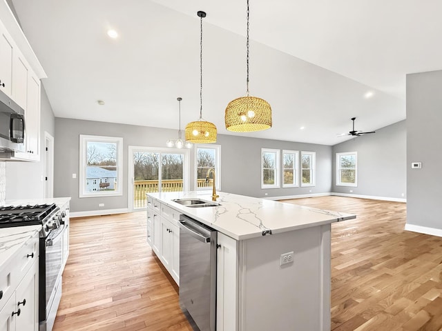 kitchen featuring sink, vaulted ceiling, an island with sink, white cabinetry, and stainless steel appliances