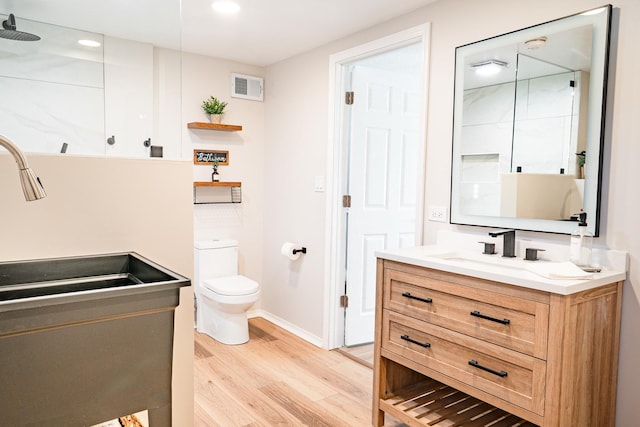 bathroom featuring vanity, hardwood / wood-style flooring, and toilet