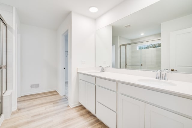 bathroom with vanity, an enclosed shower, and wood-type flooring