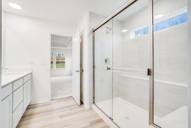 bathroom with vanity, wood-type flooring, and a shower with shower door