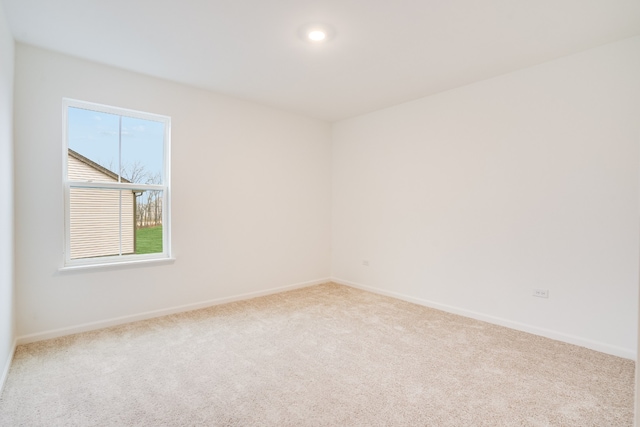 unfurnished room featuring light carpet