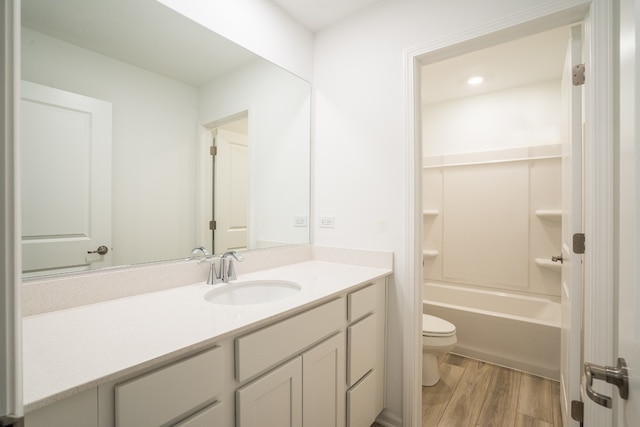 full bathroom featuring toilet, vanity,  shower combination, and hardwood / wood-style flooring