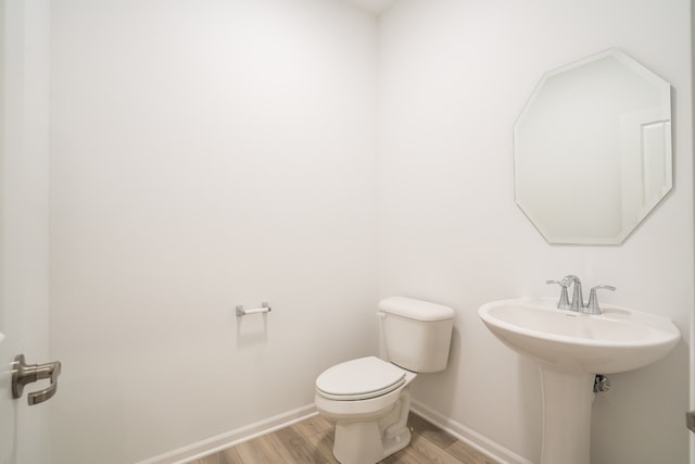 bathroom featuring toilet and wood-type flooring