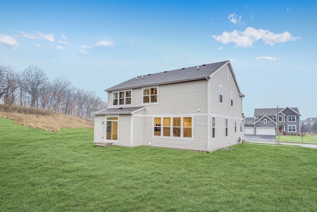 back of house with a garage and a lawn