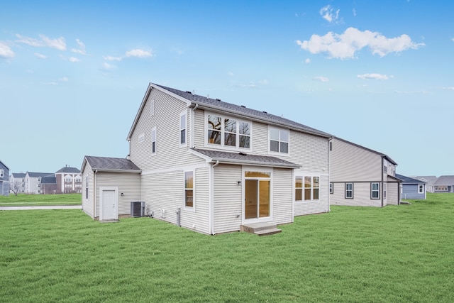 rear view of house with a yard and cooling unit