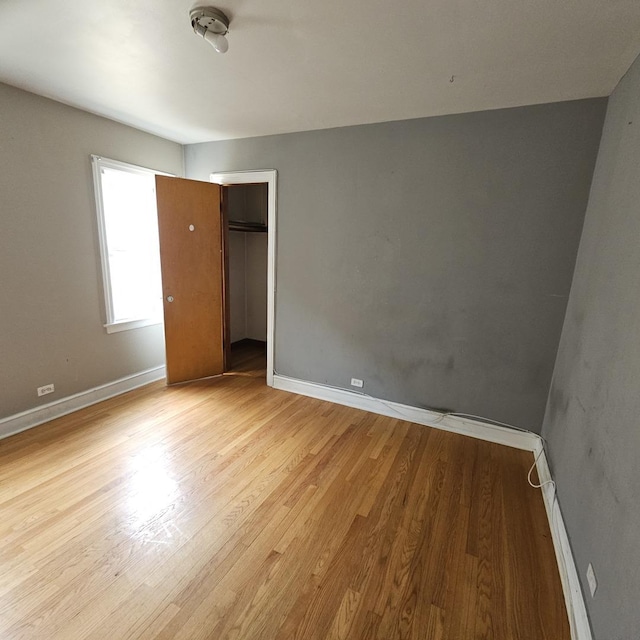 unfurnished bedroom featuring light hardwood / wood-style floors and a closet