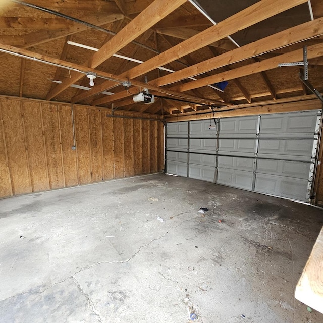 garage with a garage door opener and wood walls