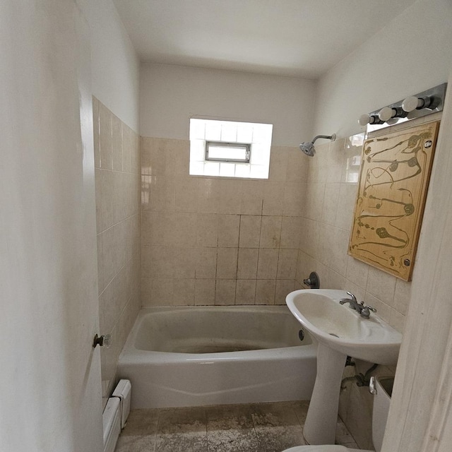 bathroom with tiled shower / bath and a baseboard heating unit