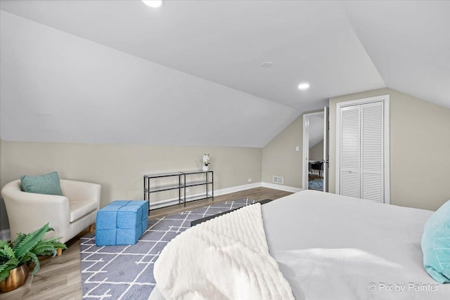 bedroom with lofted ceiling, a closet, and dark wood-type flooring