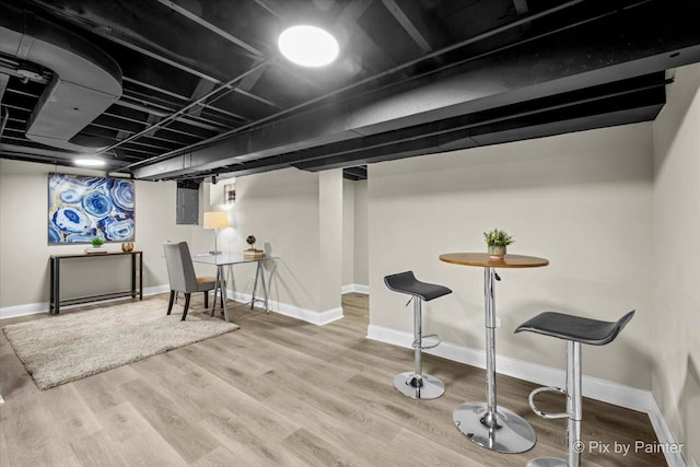 basement with wood-type flooring and electric panel