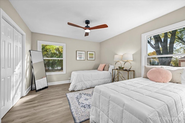 bedroom featuring ceiling fan, a closet, and light hardwood / wood-style floors