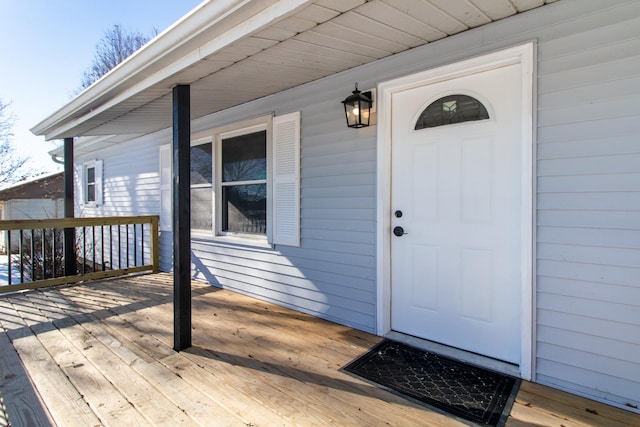 view of exterior entry with a wooden deck