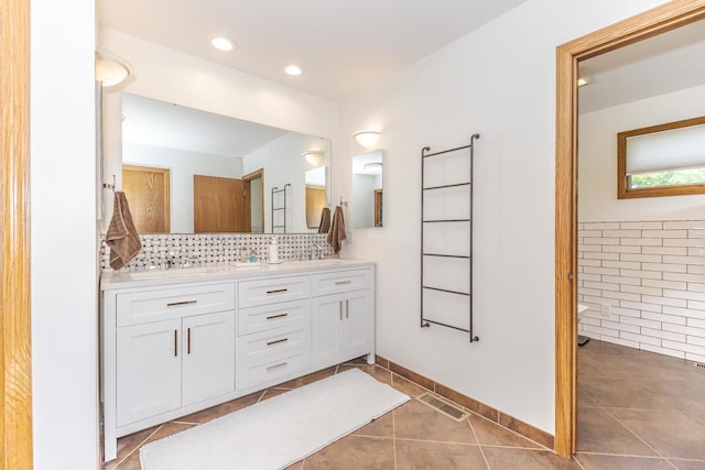 bathroom with decorative backsplash, vanity, and tile patterned floors