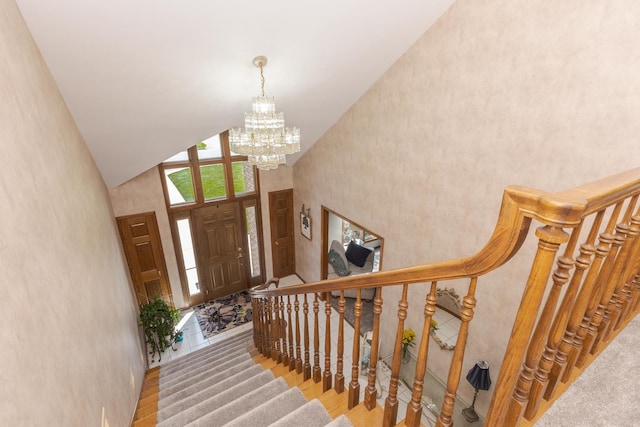 entryway featuring hardwood / wood-style flooring, high vaulted ceiling, and a notable chandelier