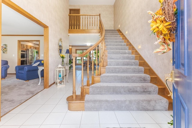 stairs featuring tile patterned floors and crown molding