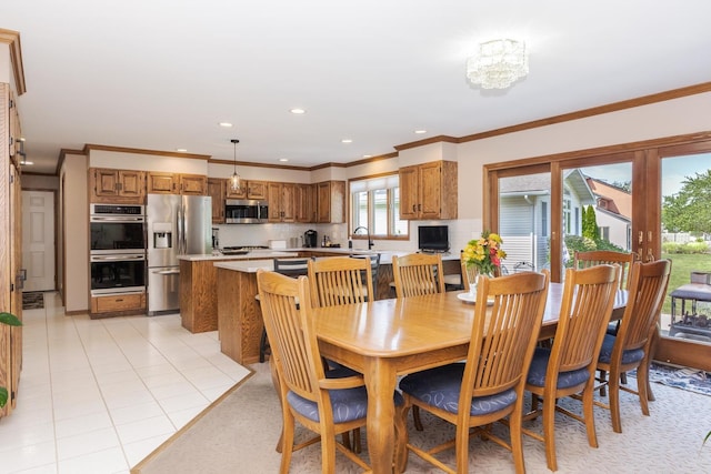 tiled dining area with a notable chandelier, ornamental molding, and sink