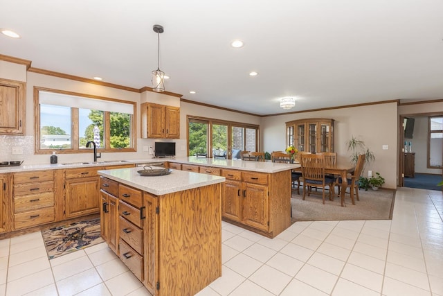 kitchen featuring sink, light tile patterned floors, tasteful backsplash, decorative light fixtures, and a kitchen island