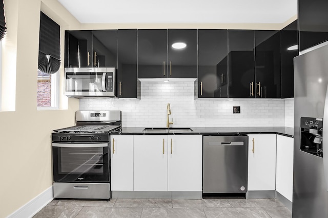 kitchen with white cabinets, decorative backsplash, sink, and stainless steel appliances