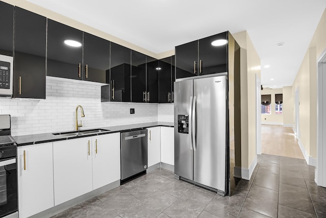 kitchen featuring stainless steel appliances, white cabinetry, tasteful backsplash, and sink