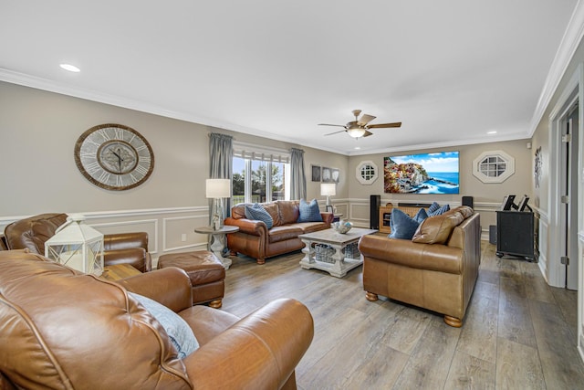 living room featuring ceiling fan, light hardwood / wood-style flooring, and ornamental molding