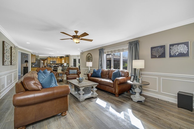 living room featuring hardwood / wood-style flooring, ceiling fan, and ornamental molding