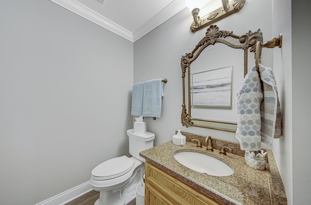 bathroom with toilet, vanity, and ornamental molding