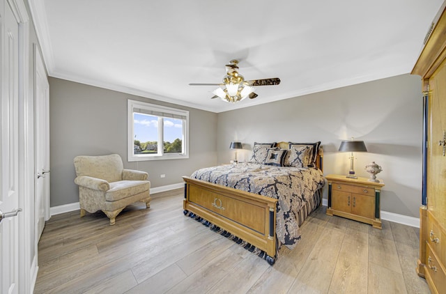 bedroom featuring ceiling fan, crown molding, and light hardwood / wood-style flooring