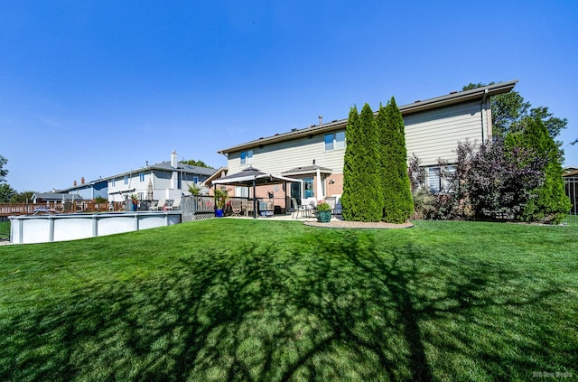 rear view of property with a gazebo and a yard