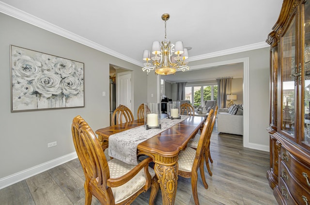 dining room with dark hardwood / wood-style flooring, ornamental molding, and a chandelier