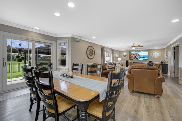 dining area with ceiling fan, ornamental molding, and light wood-type flooring