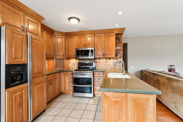 kitchen with sink, light tile patterned floors, appliances with stainless steel finishes, backsplash, and kitchen peninsula