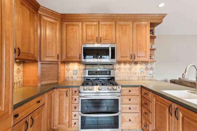 kitchen featuring stainless steel appliances, sink, and backsplash